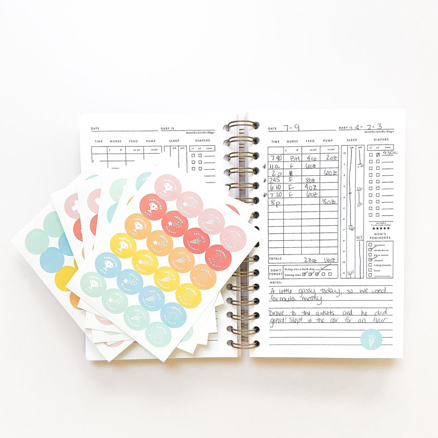 An open planner from The Everyday Mother with colorful milestone stickers on the left and a week's schedule filled out on the right, against a white background.