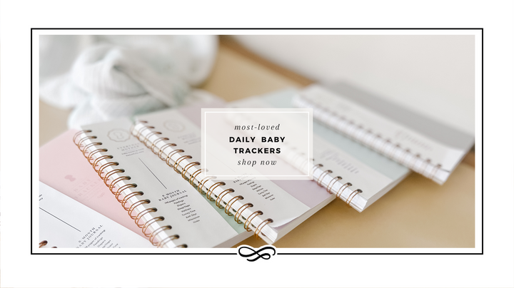 5 Pastel Color Everyday Mother Baby Tracking Journals on an ivory countertop with a burp cloth behind them